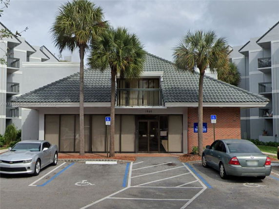 Front view of a building with a sloped roof and a brick facade.