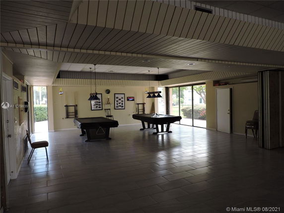 Interior of a recreation room with pool tables and seating.