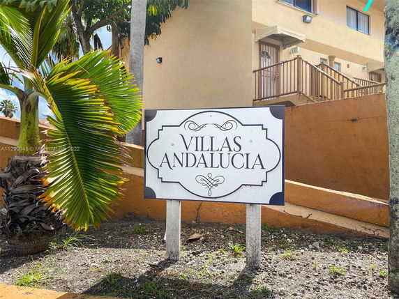 Front view of a building named Villas Andalucia with exterior stairs and windows.