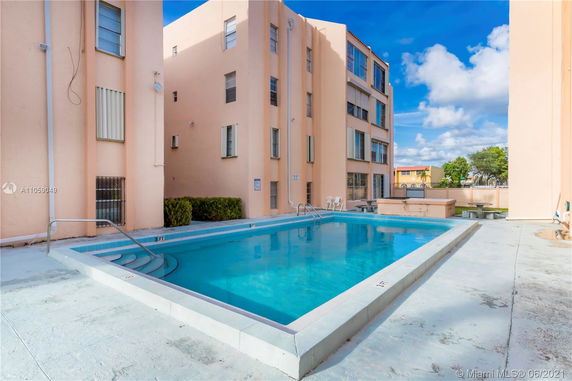 Outdoor swimming pool next to a multi-story building.