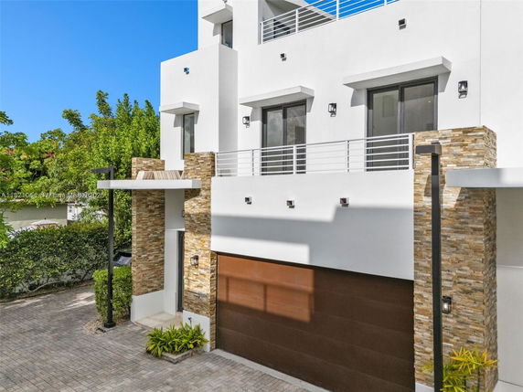 Front view of a modern multi-story house with stone accents and a double garage.