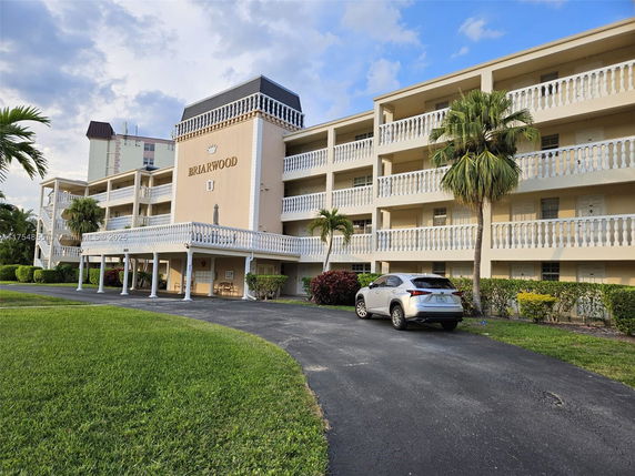 Front view of a multi-story building with balconies and a covered entrance.