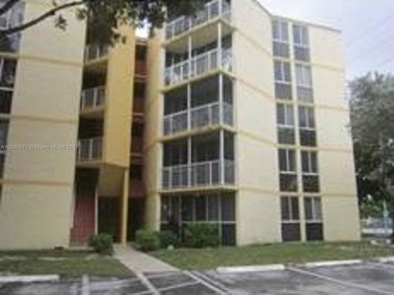 Front view of a multi-story apartment building with balconies.