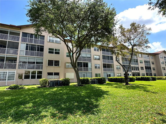 Front view of a multi-story apartment building with screened balconies.