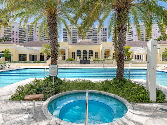 Front view of a spacious building with a pool and jacuzzi in the foreground.