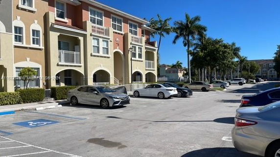 Outdoor parking area in front of a multi-story residential building.