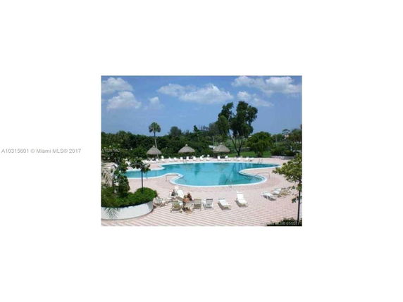 Outdoor swimming pool with lounge chairs and umbrellas.