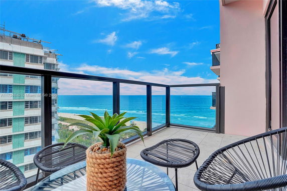Panoramic view from a balcony overlooking the ocean and surrounding buildings.