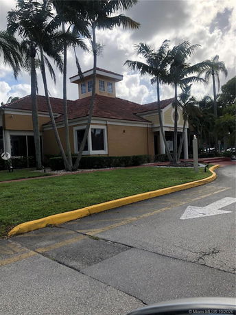 Front view of a building with a red-tiled roof and a small tower structure.