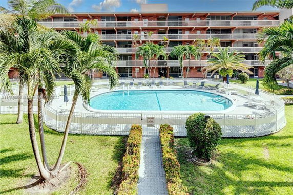 View of a building with a swimming pool in front.