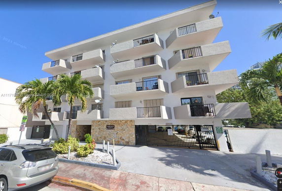 Front view of a multi-story apartment building with balconies.