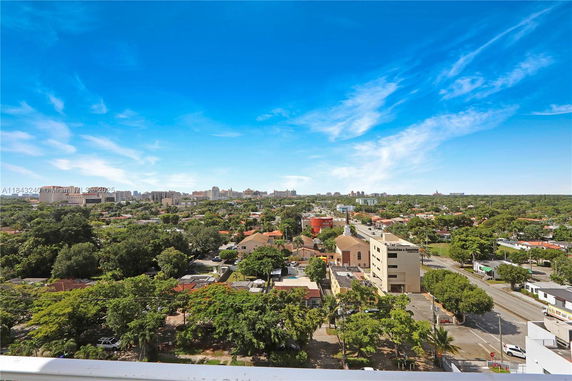 Panoramic view of a cityscape with buildings and greenery under a clear blue sky.