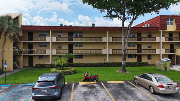 Front view of a three-story apartment building with balconies.