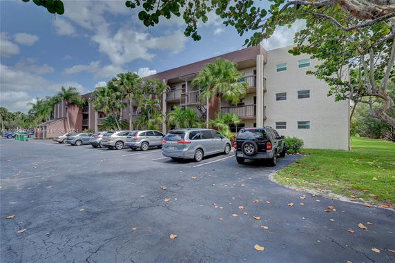Outdoor parking area in front of a multi-story residential building.