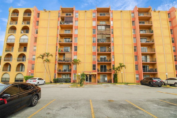 Front view of a multi-story apartment building with balconies.