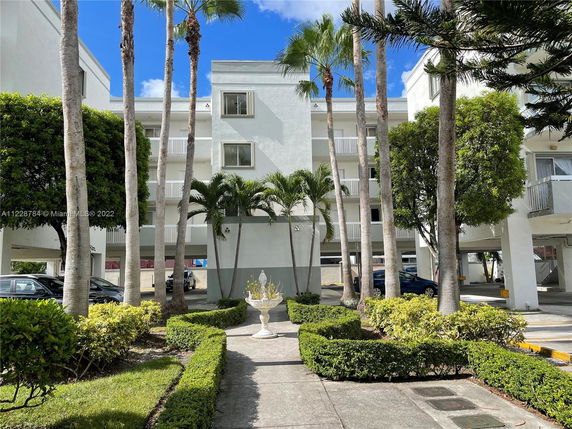 Front view of a multi-story building with white exterior and balconies.