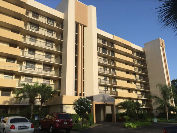 Front view of a multi-story apartment building with balconies.