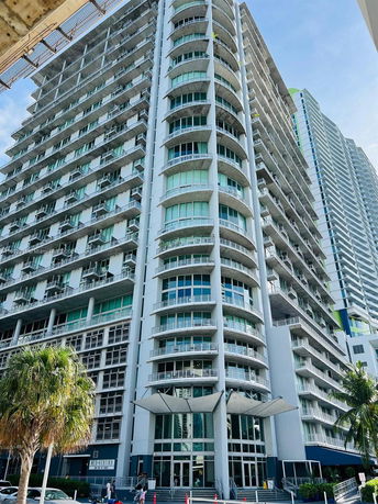 Front view of a high-rise building with multiple balconies and large glass windows.