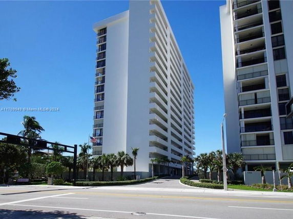 Front view of a tall residential building with balconies.