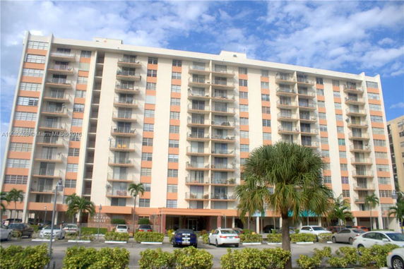 Front view of a multi-story apartment building with balconies.