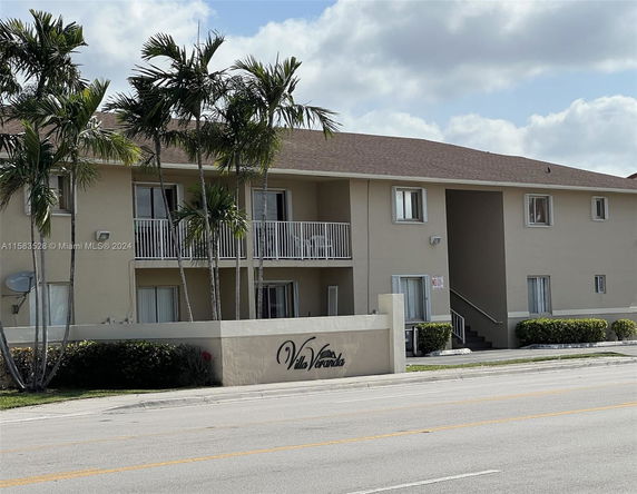 Front view of a two-story apartment building with balconies.