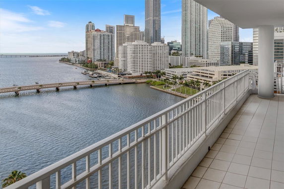 Panoramic view from a balcony overlooking a body of water and surrounding cityscape.
