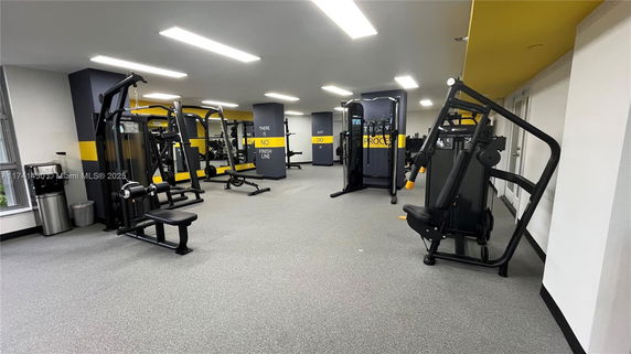 Interior view of a gym with various exercise machines and motivational quotes on the walls.