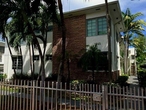 Front view of a two-story building with brick and white exterior.