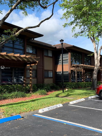 Front view of a two-story building with wooden paneling and large windows.