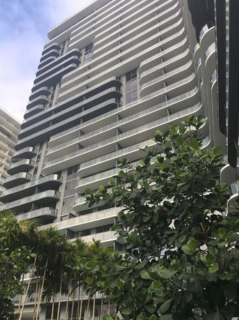 Front view of a modern multi-story building with curved balconies.