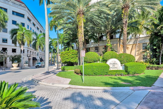 Front view of a multi-story building with palm trees.