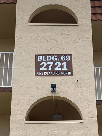 Front view of a building with arch design and visible building number signage.