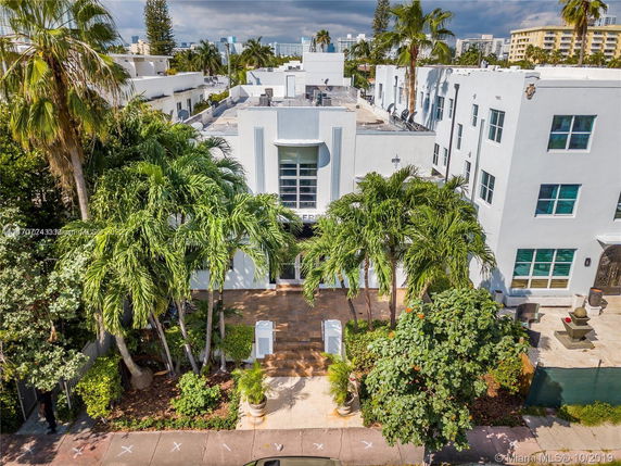Front view of a multi-story building with palm trees.