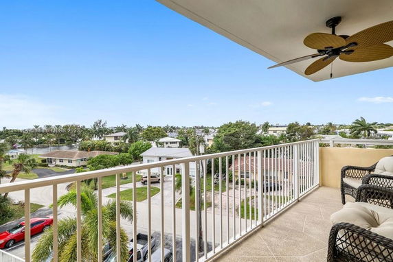 View from a balcony overlooking a neighborhood with multiple houses and trees.
