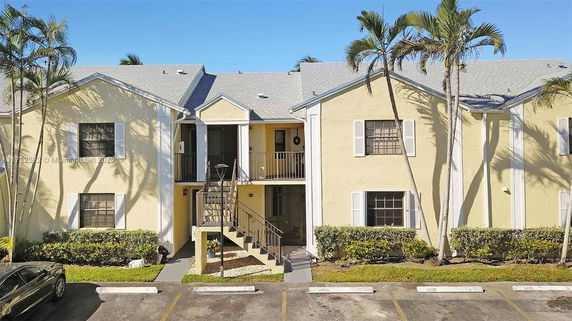 Front view of a two-story residential building with a staircase leading to the upper level.