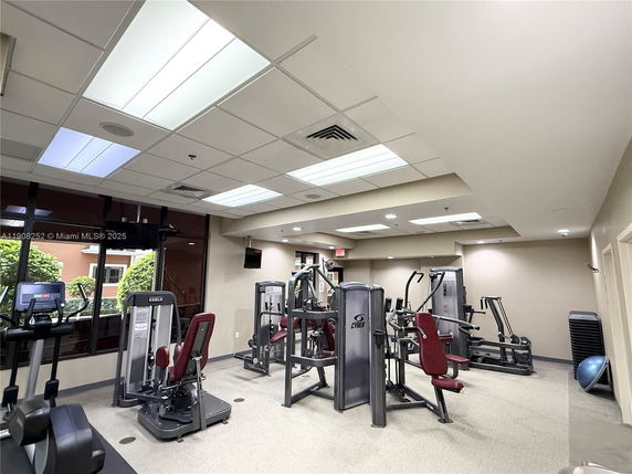 Indoor gym area with exercise equipment and machines.