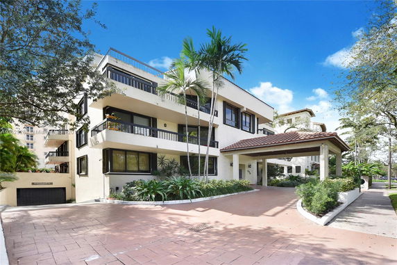 Front view of a multi-story residential building with balconies and covered entrance.