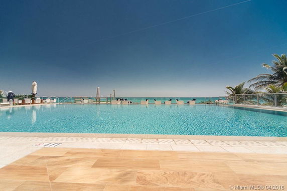 View from poolside overlooking the ocean with clear blue skies.
