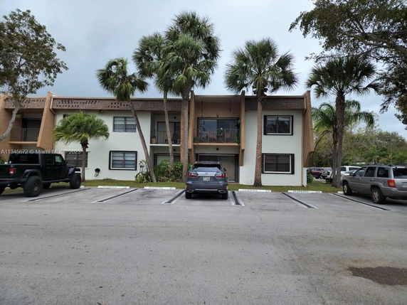 Front view of a two-story residential building with parking spaces in front.