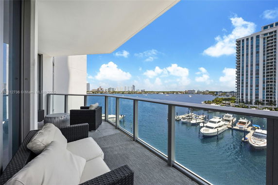 Balcony view overlooking a body of water and distant cityscape.