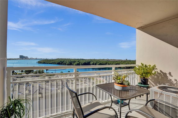 View from a balcony overlooking a body of water and greenery.