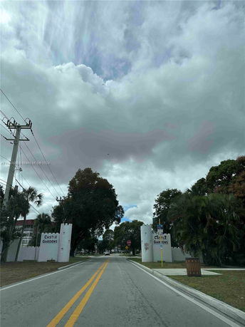 Entrance view of a residential area with signs reading 'Castle Gardens'.