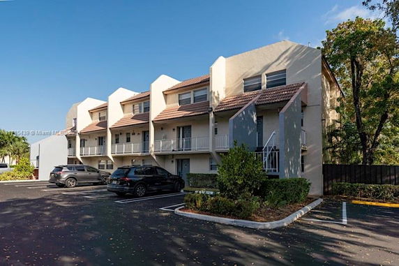Front view of a row of townhouses with sloped roofs and balconies.
