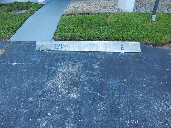 Outdoor parking space with a painted curb stop.