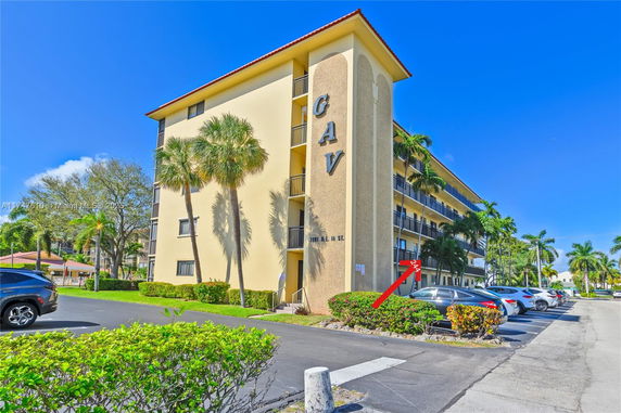 Front view of a multi-story building with a flat roof and balconies.