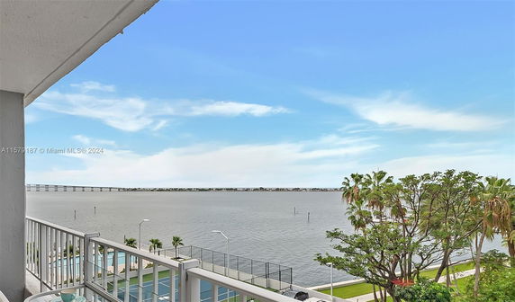 Panoramic view from a balcony overlooking a body of water with a bridge in the distance.