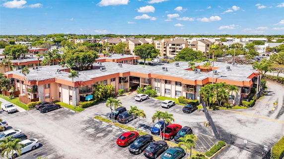 Aerial view of a residential complex with multiple buildings and parking spaces.