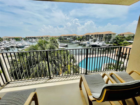 Panoramic view of a marina and surrounding buildings from a balcony.