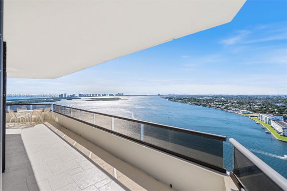 Wide-angle view from a balcony overlooking a large body of water and cityscape.
