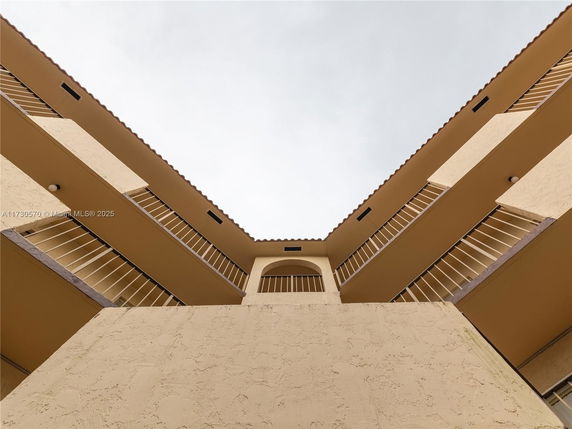 Upward view of multi-story building with balconies.